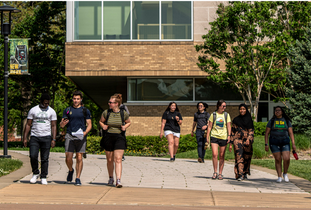 A diverse mix of students walk towards the Havener Center on campus